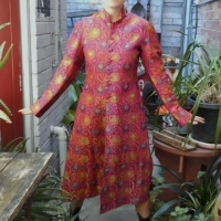Lot 195 - Vintage ladies Chinese long brocade silk coat with mandarin collar - pink ground covered in stylised flowers, goldpurplecream, small top pockets, quil - Sold for $85 - 2016