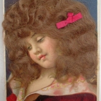 Novelty Edwardian postcard of pretty girl with real long hair & red bow - Sold for $18 - 2012