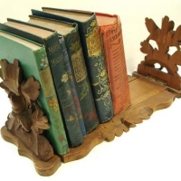 Black Forest carved sliding bookstand with selection of books - decorative bindings and Pears Cyclopeadia - Sold for $31 - 2016