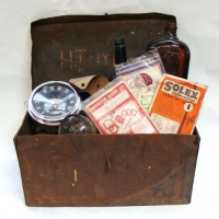 Lot 74 - Vintage tin tool box and contents inc - Gasket kits (Solex, Mopar, Tudor, Holley, etc), Vintage speedometers, bottles, etc - Sold for $50