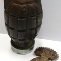 Lot 287 - 2 x items inc - vintage cast iron grenade money box and Grenadiers badge - Sold for $43
