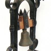 Vintage brass bell with raised decoration on wall hanging cast stand - Sold for $68