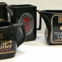 4 x black glazed ceramic advertising jugs inc - Hedges and Butler, Black Douglas, Bathams and Tennents Lager - Sold for $75 - 2017