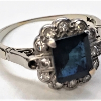 Ladies 18ct white gold ring set with oblong dark blue sapphire surrounded by 12 small diamonds - Sold for $236 - 2018