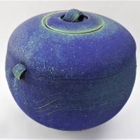 Post War Australian pottery - Janet De Boos lidded spherical vessel, purple with green dry glaze with raised wavy decoration to girth, incised signatu - Sold for $50 - 2018