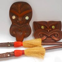 Group of Carved wooden Maori items - 2 wall Masks and miniature Tai Ha - Sold for $43 - 2018