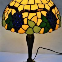 Tiffany style table lamp with bronze tone ornate base and stained glass shade with stylised grape and leaf design, approx 60cm H - Sold for $56 - 2019