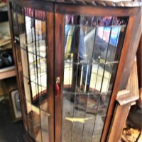 Circa-1930s-Tudor-style-wooden-mirror-backed-corner-Display-cabinet-rounded-front-with-leadlight-clear-and-coloured-glass-glass-shelving-approx-13-Sold-for-137-2019