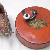 2 items - Victorian round metal MUSIC BOX with small brass handle & porcelain knob & miniature metal Victorian PRAM with tiny baby with dummy in layet - Sold for $171 - 2008