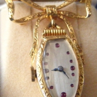 Vintage 18ct gold Ladies WATCH BROOCH with watch hanging from bow, small rubies to watch face, total 121g, works - Sold for $220 - 2009