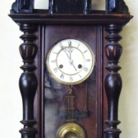 Timber Cased PENDULUM WALL CLOCK with ornate case featuring eagle, turned finials and other decoration, enamelled face, pendulum and key prese - Sold for $171 - 2009