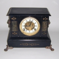 Victorian  ANSONIA striking MANTLE CLOCK - black tin case with cast iron feet & LIONS HEAD to each side - gilt & enamel dial with VISIBLE ESCAPEMENT - - Sold for $317 - 2009