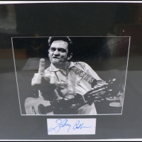 Mounted JOHNNY CASH signed card & B&W photo - signed in blue marker to card - with COA to back - 26 x 25cm - Sold for $464 - 2009