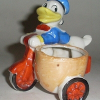 1930's Walt Disney Prod  Novelty egg cup - DONALD DUCK riding bike - Sold for $67 - 2012