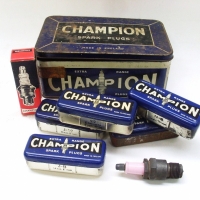 Group lot vintage motoring tins, inc Champion Spark Plugs, one quart oil bottle and Lodge CB3 Spark Plug with porcelain top - Sold for $67 - 2012