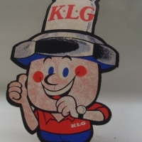 Coloured KLG point of sale cardboard show card - comical character wearing spark plug hat - 49cms H - Sold for $55 - 2012