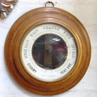METALLIC BAROMETER in thick wooden round surround, unusual metal band mechanism, makers mark not sighted, 33 cm diam - Sold for $134 - 2012