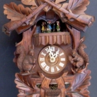 Ornately carved wooden cuckoo clock with dancing couples and metal acorn pendulums - Sold for $110 - 2013