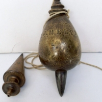 2 plumb bobs, one inscribed Stanley London, one  very heavy inscribed F Meldrum plus ornate ceramic and brass cistern pull - Sold for $146 - 2013