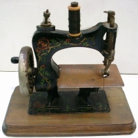 Edwardian toy sewing machine on wooden base with floral decoration - Sold for $122 - 2013