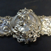 c1900 ornate Silver plated nurses Belt with Art Nouveau buckle featuring embossed portrait of a girl,  embossed cherubs to square panels - Sold for $159 2014