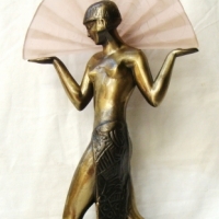 Striking  ART DECO style lamp -  brass coloured maiden with raised arms holding a fan shaped pink glass shade Stepped stippled green marble like base  - Sold for $146 - 2014