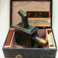 Circa 1900 Gebruder Bing of Germany - Child's MAGIC LANTERN in original wooden box complete with approx 26 coloured glass slides - Sold for $146 - 2015