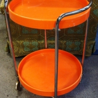 Retro bright orange plastic & chrome two tier wheeled occasional table - Sold for $61