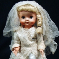 1950's hard plastic walker bride doll with sleep eyes, blonde plaited hair, molded shoes & closed mouth Marked Made in England to back, possRosebud -A - Sold for $43 - 2015