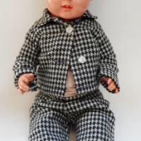 Circa 1930's German Schildkrot CELLULOD DOLL with blue glass eyes, open mouth, teeth showing, molded hair, dressed in black white hounds tooth suit -  - Sold for $122 - 2015