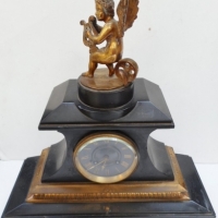Vintage ornate black slate mantle clock with gilt embellishment, stand and cherub figure to top - with original key and pendulum - Sold for $183 - 2015