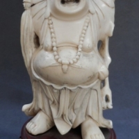 Carved ivory ' happy ' Buddha figurine with up stretched arms  on carved wooden base - total H 16cms - Sold for $464 - 2015